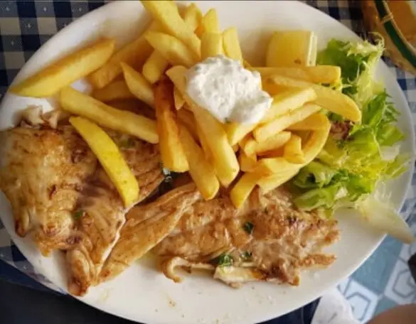 Pescado a la plancha y patatas fritas con alioli en la Pescaderia El Artesano en Nerja Malaga